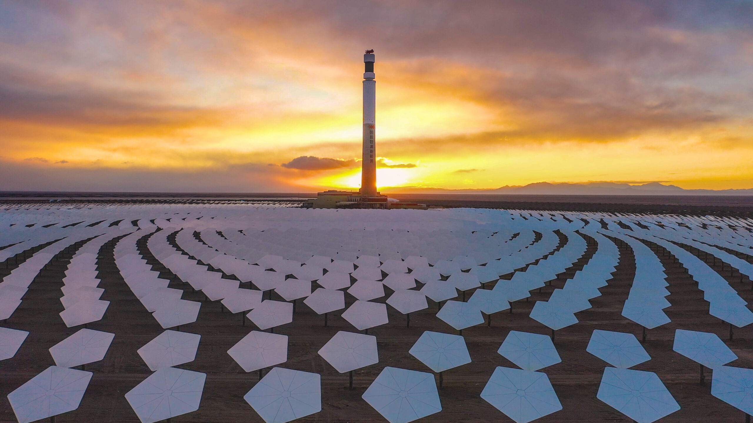 Heliostaty w elektrowni CSP Gansu w Chinach z widokiem na wieżę w tle.